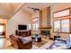 Sunlit living room features a brick fireplace, vaulted ceilings, and hardwood floors at 17085 E Dorado Cir, Centennial, CO 80015