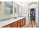 Bathroom with double sinks, wooden cabinets, large mirrors, and blue accents at 11230 Osage Cir # B, Northglenn, CO 80234