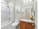 Bright bathroom with white tub, shower, tile, and a wood vanity at 11230 Osage Cir # B, Northglenn, CO 80234