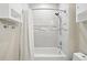 Bright bathroom with white tub and shower, white tile, and a shower curtain at 11230 Osage Cir # B, Northglenn, CO 80234