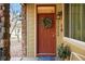 Charming front door with wreath and visible address, complemented by stone accents and manicured landscaping at 11230 Osage Cir # B, Northglenn, CO 80234