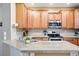 A kitchen with wood cabinets, granite countertops, and stainless steel appliances at 11230 Osage Cir # B, Northglenn, CO 80234
