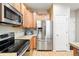 The kitchen has stainless steel appliances, granite countertops, and hardwood floors at 11230 Osage Cir # B, Northglenn, CO 80234