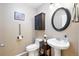 Nicely decorated powder room featuring a pedestal sink, toilet, and dark cabinet at 11230 Osage Cir # B, Northglenn, CO 80234