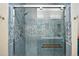 Clean bathroom shower with textured blue tiling, mosaic accents, glass doors, and chrome fixtures at 11230 Osage Cir # B, Northglenn, CO 80234