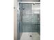 Close up of a shower with blue tile, glass doors, and a modern showerhead at 11230 Osage Cir # B, Northglenn, CO 80234