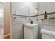 A modern bathroom with horizontal tiling, vanity sink, and compact toilet in neutral, elegant design at 1175 N Emerson St # 103, Denver, CO 80218