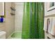 Well-lit bathroom with a green shower curtain and modern tile accents at 1175 N Emerson St # 103, Denver, CO 80218