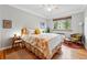 Comfortable bedroom with hardwood floors, a ceiling fan, and a large window offering natural light and views at 1175 N Emerson St # 103, Denver, CO 80218