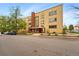 A three-story yellow brick building with a prominent entrance and well-maintained landscaping at 1175 N Emerson St # 103, Denver, CO 80218