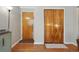Inviting hallway features wood floors, front door, and a closet with natural wood sliding doors at 1175 N Emerson St # 103, Denver, CO 80218
