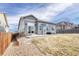 Back exterior of a home featuring a stone patio, a fenced yard, and mountain views at 6495 S Harvest St, Aurora, CO 80016