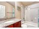 Bathroom featuring a vanity with a granite countertop, a mirror, and a tiled shower at 6495 S Harvest St, Aurora, CO 80016