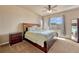 Comfortable main bedroom with a ceiling fan, a night stand, and nice natural light from the large windows at 6495 S Harvest St, Aurora, CO 80016
