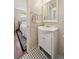 Bathroom with a classic white sink and vanity, with black and white patterned tile at 8250 Chase Way, Arvada, CO 80003