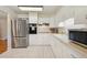 Well-lit kitchen features white cabinets, modern appliances, and tile floors for easy maintenance at 8250 Chase Way, Arvada, CO 80003
