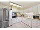 Bright kitchen with stainless steel appliances, white cabinetry, and durable tile flooring for functionality at 8250 Chase Way, Arvada, CO 80003