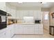 Functional kitchen features white cabinetry, tile floors, ample counter space, and modern appliances at 8250 Chase Way, Arvada, CO 80003