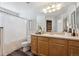 Well-lit bathroom features wood-look flooring, vanity with mirror, and shower with white curtain at 5193 E 119Th Way, Thornton, CO 80233