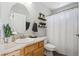 Bathroom with wood vanity, oval mirror, and shower with diamond-patterned curtain at 5193 E 119Th Way, Thornton, CO 80233