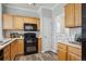 Well-lit kitchen featuring wood cabinetry, modern appliances, and convenient access to the laundry area at 5193 E 119Th Way, Thornton, CO 80233