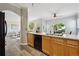 Open kitchen with stainless steel appliances, wood cabinets, and a view of the dining and living areas at 5193 E 119Th Way, Thornton, CO 80233