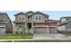 Two-story home with mixed siding, stone accents, three-car garage, and a well-maintained front yard at 4592 Windmill Dr, Brighton, CO 80601