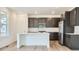 Beautiful kitchen featuring dark cabinets, stainless steel appliances, and a central island with white countertops at 4592 Windmill Dr, Brighton, CO 80601