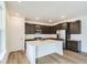 Modern kitchen with dark cabinets, stainless steel appliances, and a central island with quartz countertops at 4592 Windmill Dr, Brighton, CO 80601