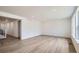 Bright, open-concept living room with light wood floors and ample natural light streaming through the windows at 4592 Windmill Dr, Brighton, CO 80601