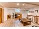 Bright basement area with modern floors, brick fireplace, wooden storage units, and natural light at 7785 W 5Th Ave, Lakewood, CO 80226
