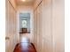 Hallway with hardwood floors and closet space that leads into a room with natural light at 7785 W 5Th Ave, Lakewood, CO 80226