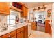 Traditional kitchen with wooden cabinets, white countertops, and a view into the adjacent living room at 7785 W 5Th Ave, Lakewood, CO 80226