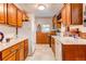 Galley-style kitchen with wood cabinets, white appliances, and tile flooring offers a cozy cooking space at 7785 W 5Th Ave, Lakewood, CO 80226