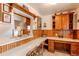 Cozy kitchen with breakfast bar seating, wooden cabinets, white countertop, and an attached desk area at 7785 W 5Th Ave, Lakewood, CO 80226