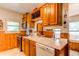 Charming kitchen features wood cabinets, white countertops, stainless steel appliances, and tile flooring at 7785 W 5Th Ave, Lakewood, CO 80226