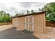 Exterior of tan storage shed with double doors and rock surround at 7785 W 5Th Ave, Lakewood, CO 80226