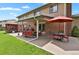 Backyard patio featuring an outdoor kitchen, seating area, and lush lawn at 7784 Lewis St, Arvada, CO 80005