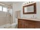 Bathroom featuring a glass shower, double vanity, and decorative mirror at 7784 Lewis St, Arvada, CO 80005