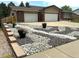 Charming home with a two-car garage and decorative rock landscaping featuring flower pots at 7784 Lewis St, Arvada, CO 80005