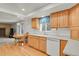 Charming kitchen features light wood cabinets, modern white appliances, and adjacent dining area at 7784 Lewis St, Arvada, CO 80005