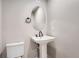 Small bathroom with pedestal sink, toilet and oval mirror at 2570 Josephine Way, Superior, CO 80027