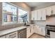 Modern kitchen with white cabinets, herringbone tile backsplash and a large window at 2570 Josephine Way, Superior, CO 80027