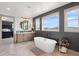 Luxurious bathroom featuring soaking tub, dual sinks, and oversized windows with stunning view at 5623 Raintree Dr, Parker, CO 80134