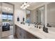Elegant bathroom featuring double sinks, modern fixtures, and a view into the bedroom at 5623 Raintree Dr, Parker, CO 80134