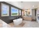 Spa-like bathroom featuring a soaking tub, dual vanities, and oversized windows with natural light at 5623 Raintree Dr, Parker, CO 80134