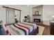 Cozy bedroom with a modern fireplace, office area, and a sliding barn door to the bathroom at 5623 Raintree Dr, Parker, CO 80134