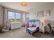 Bright bedroom with a large window, whimsical decor, and plush carpet flooring at 5623 Raintree Dr, Parker, CO 80134