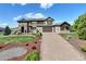 Beautiful two-story home boasts a brick driveway, manicured lawn, and mature landscaping at 5623 Raintree Dr, Parker, CO 80134