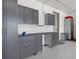 Well-organized garage with ample storage cabinets, a workbench, and epoxy flooring at 5623 Raintree Dr, Parker, CO 80134